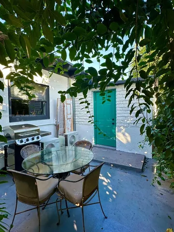 a backyard of a house with table and chairs