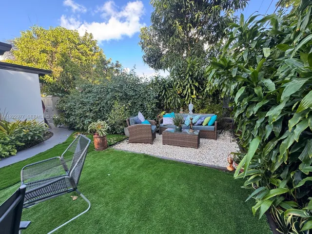 a view of a chair and table in backyard of the house