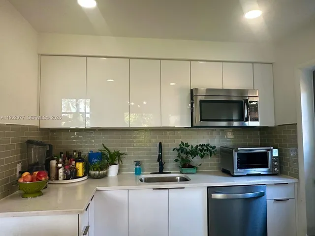 a kitchen with stainless steel appliances granite countertop a sink a stove and a microwave