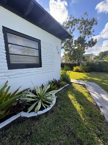 a view of a backyard with plants and a lounge chair