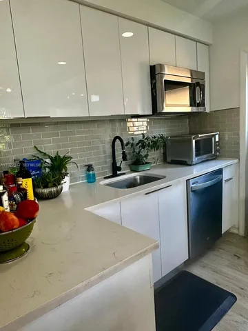 a kitchen with a sink a microwave and cabinets