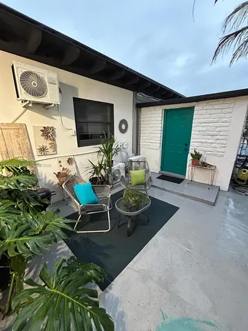 a living room with patio furniture and a flat screen tv