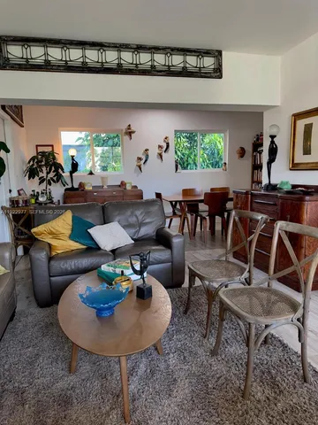 a living room with couches a coffee table and a potted plant