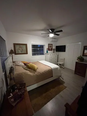 a bed room with a bed furniture and a flat tv screen