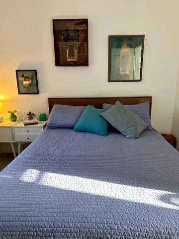 a bedroom with a bed and a painting on the wall