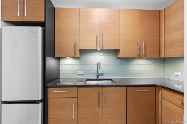 a kitchen with stainless steel appliances granite countertop a refrigerator a sink a stove a microwave and cabinets