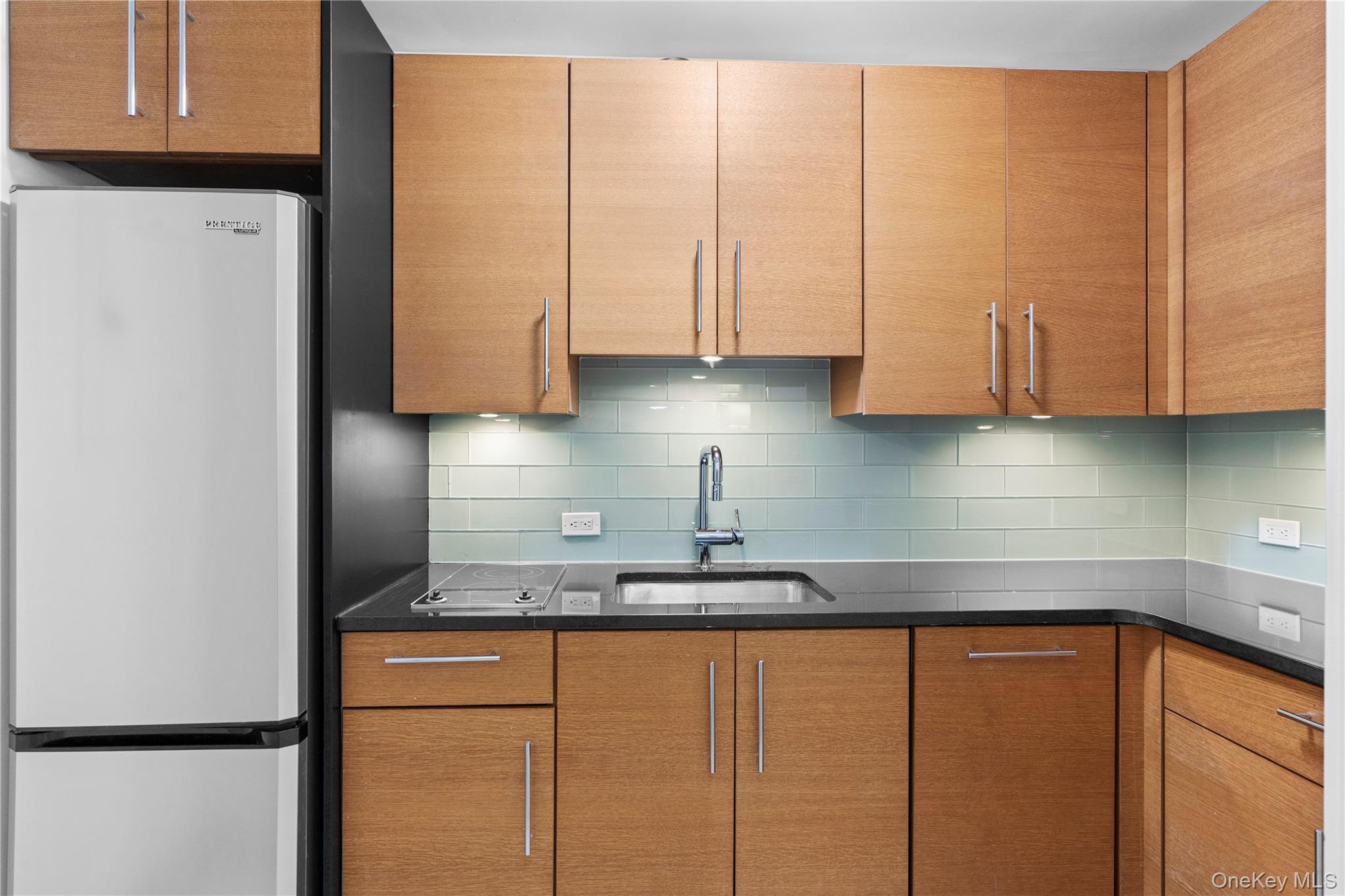 1 Renaissance Square, Unit 10B White Plains, NY 10601 - Photo 27 of 36 a kitchen with stainless steel appliances granite countertop a refrigerator a sink a stove a microwave and cabinets