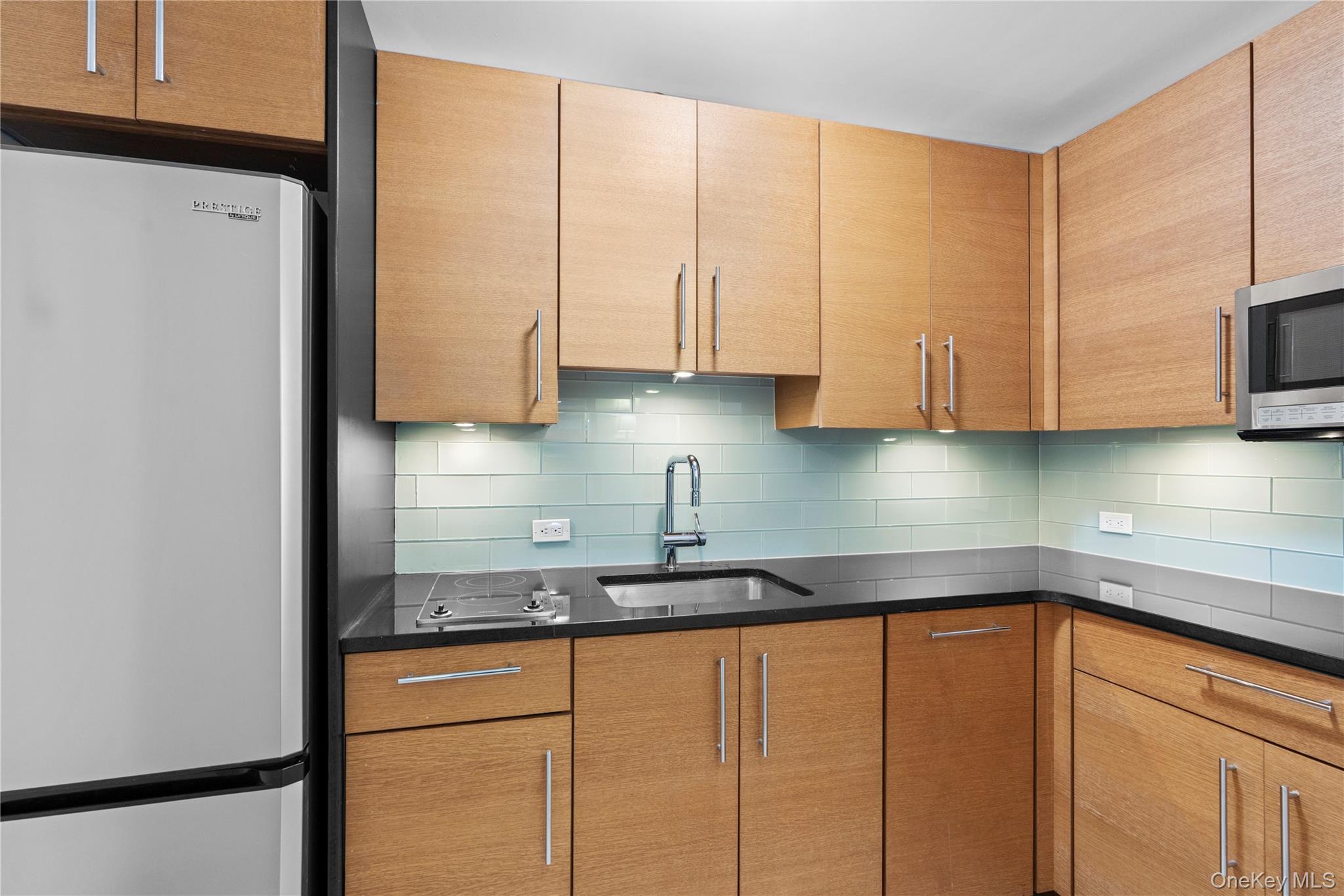 1 Renaissance Square, Unit 10B White Plains, NY 10601 - Photo 28 of 36 a kitchen with stainless steel appliances granite countertop a sink a refrigerator and a white cabinets