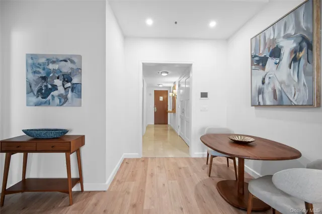 a view of a hallway with furniture and wooden floor