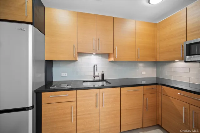 a kitchen with stainless steel appliances granite countertop a sink a stove and a refrigerator