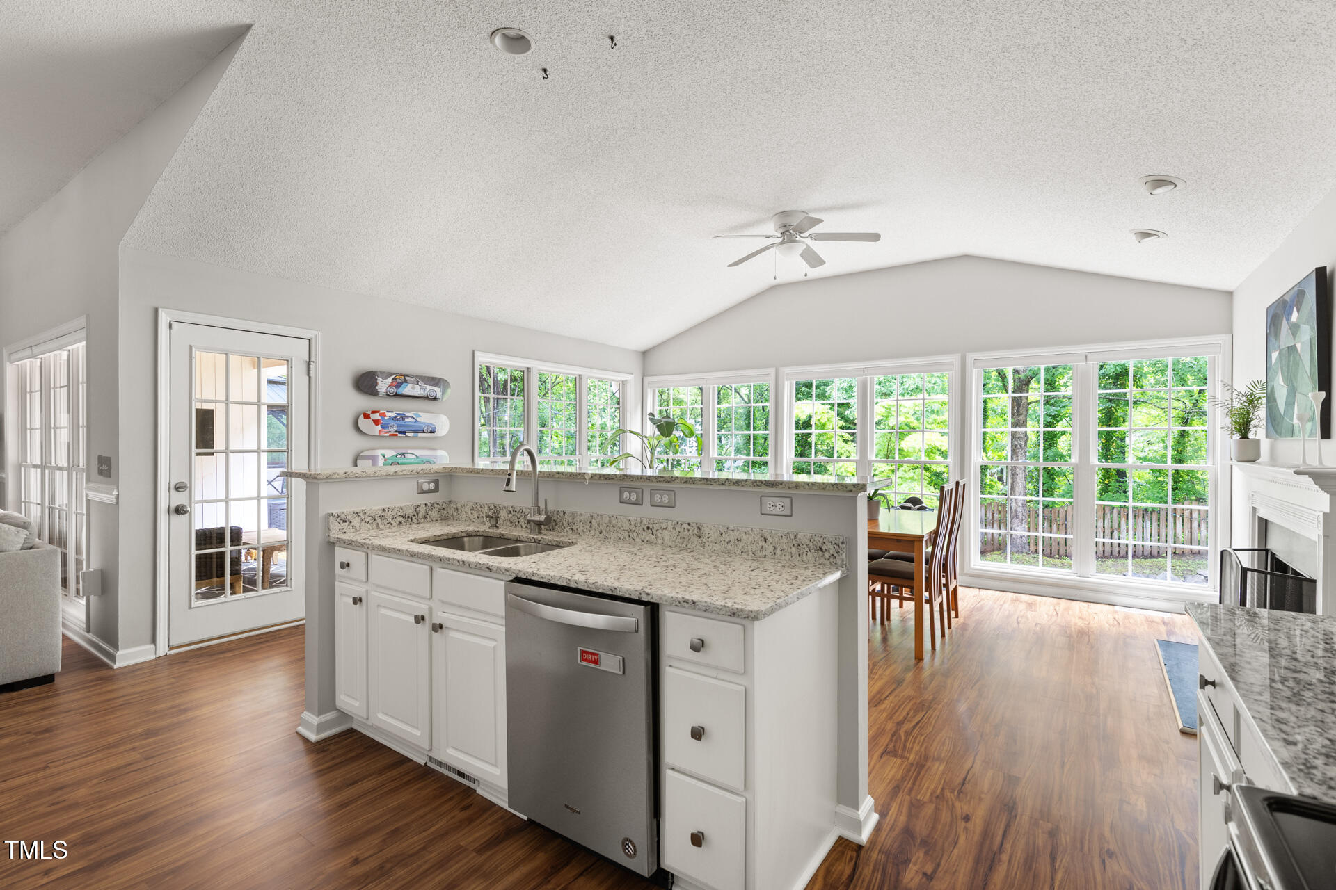 2301 Bolingbrook Lane Raleigh, NC 27613 - Photo 13 of 36 a kitchen with granite countertop a stove a sink a dining table and chairs with wooden floor