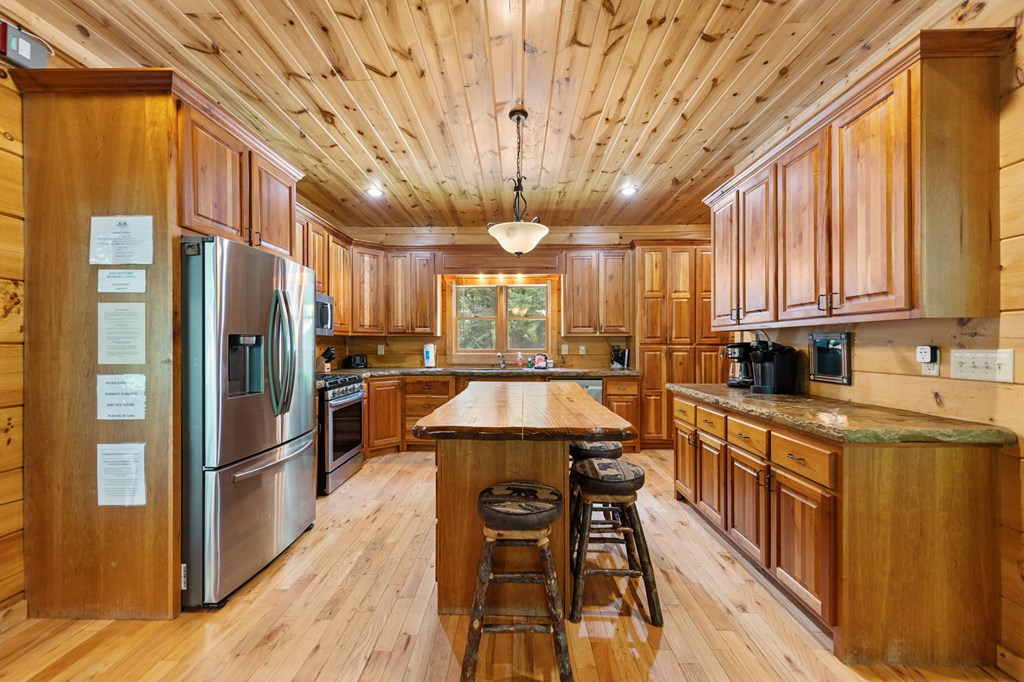 1082 Sunset Road Epworth, GA 30541 - Photo 46 of 98 a kitchen with stainless steel appliances a refrigerator a sink dishwasher a stove and a dining table with wooden floor