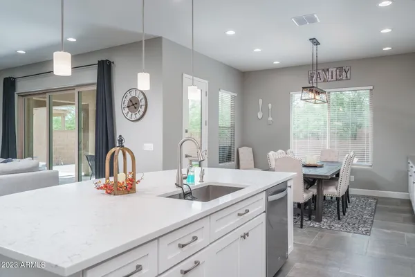 a kitchen with a table chairs and white cabinets