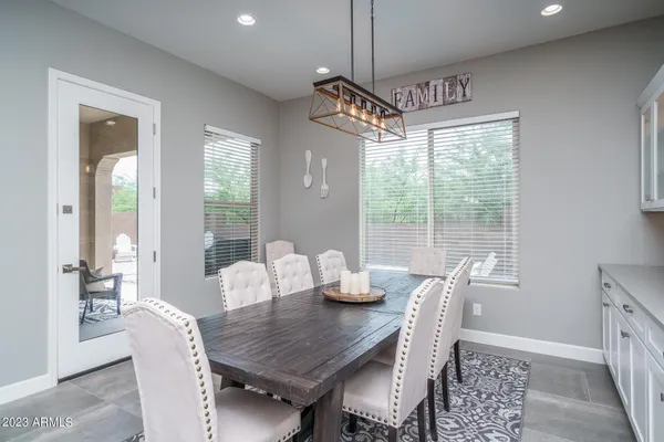 a dining room with furniture a chandelier and wooden floor