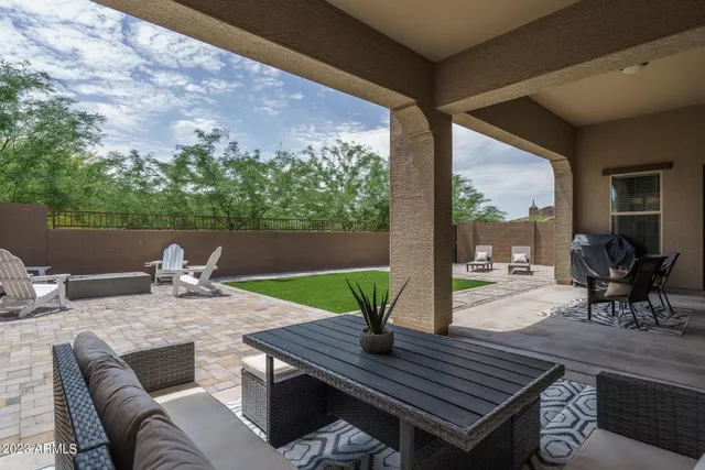 a backyard of a house with table and chairs