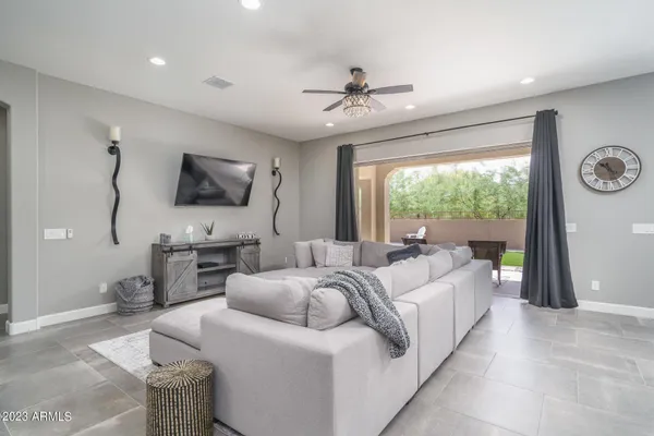 a living room with furniture a flat screen tv and a large window