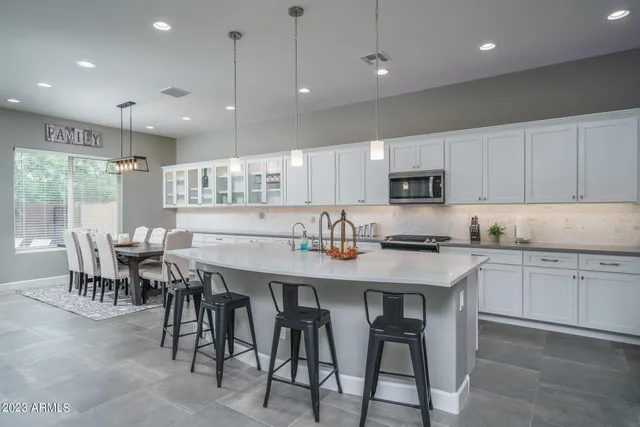 a kitchen with cabinets table and chairs