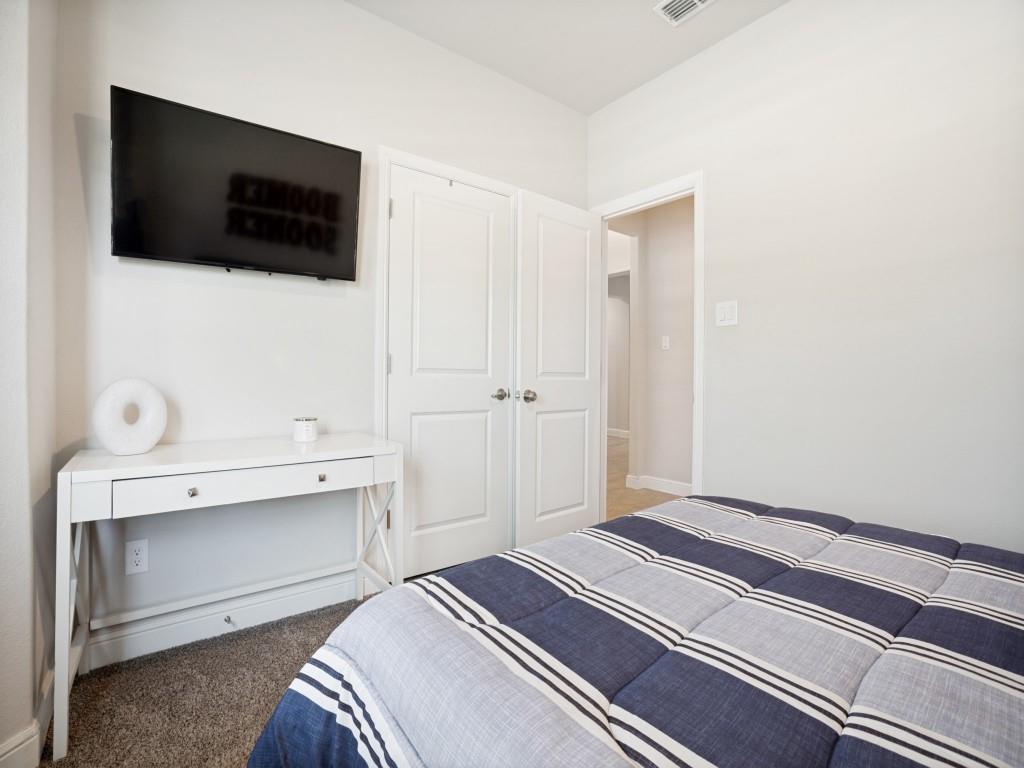 1612 Reed Drive Krum, TX 76249 - Photo 17 of 25 Neutral wall finishes with crisp white trim, plush carpeted flooring, and a ceiling-mounted air vent