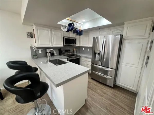 a kitchen that has a sink stainless steel appliances and cabinets