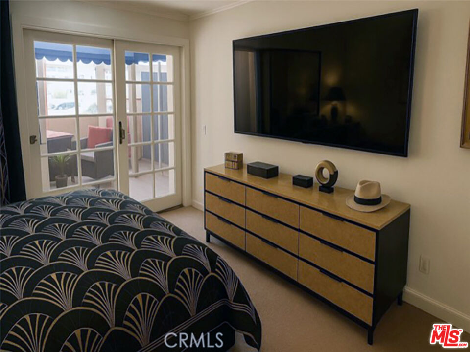 500 East Amado Road, Unit 420 Palm Springs, CA 92262 - Photo 7 of 13 a bedroom with a bed and a flat tv screen on dresser
