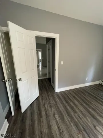 an empty room with wooden floor and window