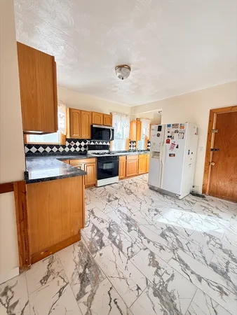 a kitchen with stainless steel appliances granite countertop a stove refrigerator and a sink