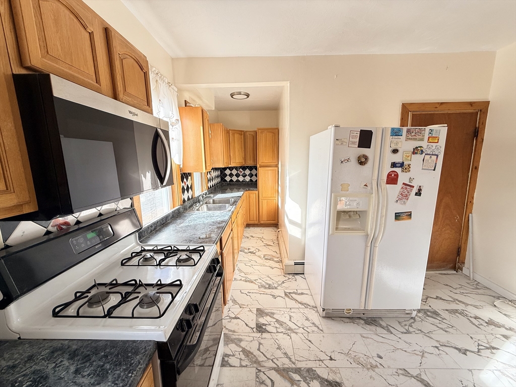 253 Norfolk Street, Unit 3 Boston, MA 02124 - Photo 2 of 14 a kitchen with stainless steel appliances granite countertop a refrigerator stove and sink