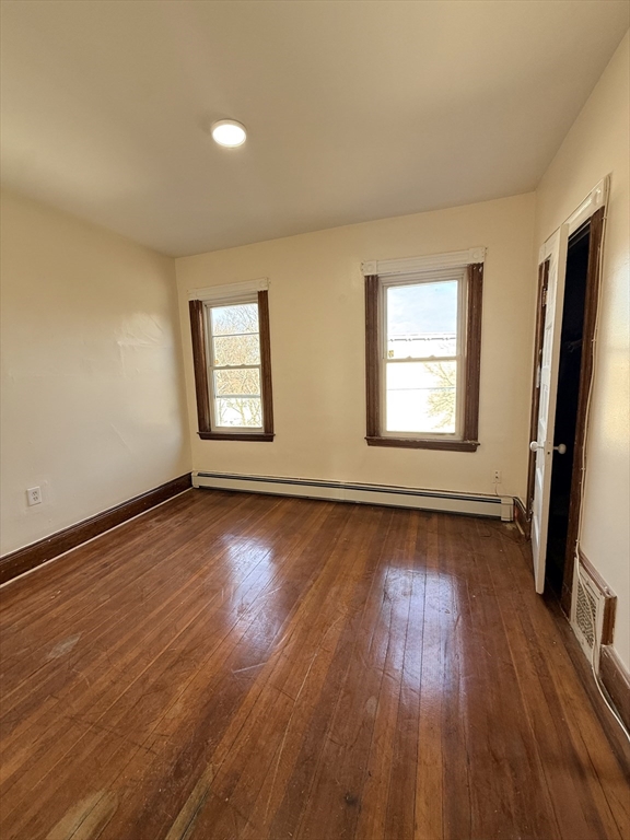 253 Norfolk Street, Unit 3 Boston, MA 02124 - Photo 7 of 14 an empty room with wooden floor and windows