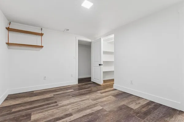 a view of empty room with wooden floor