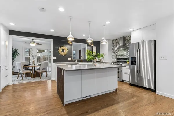 a kitchen with stainless steel appliances kitchen island granite countertop a refrigerator and a stove top oven