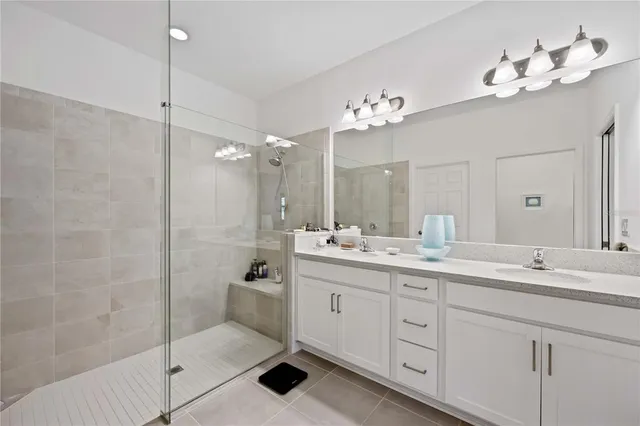 a spacious bathroom with a double vanity sink double mirror and bathtub