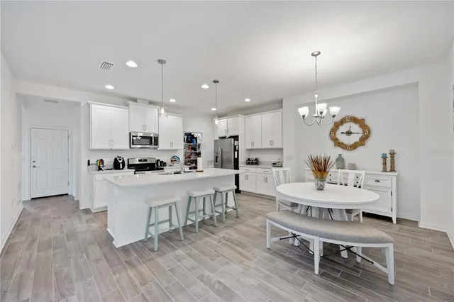 a living room with stainless steel appliances kitchen island granite countertop furniture wooden floor and a view of kitchen