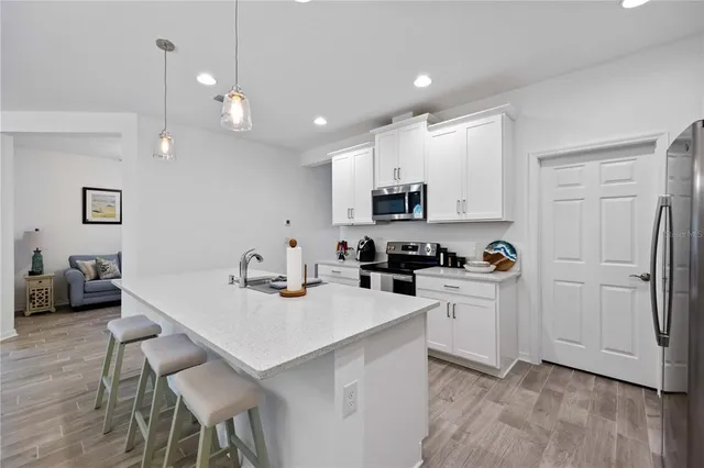 a kitchen with white cabinets and stainless steel appliances