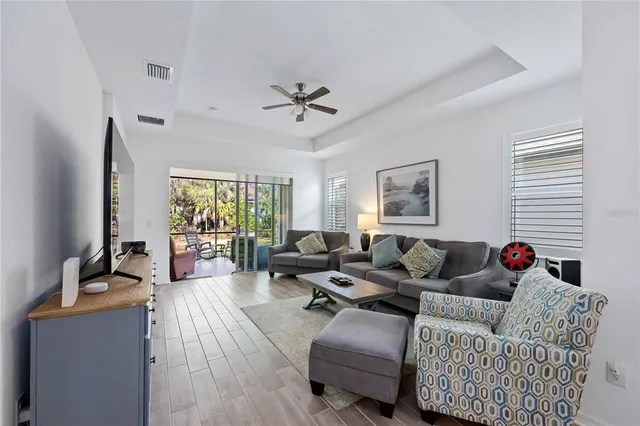 a living room with furniture ceiling fan and a window