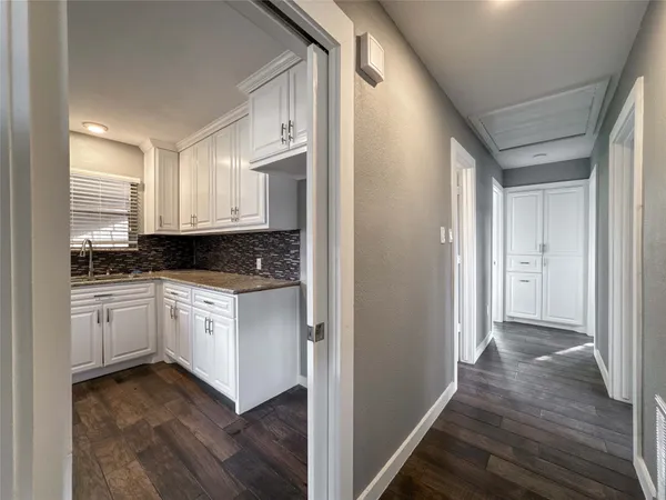 a view of a hallway with bathroom and wooden floor