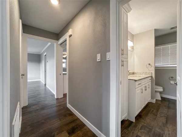a bathroom with a granite countertop toilet sink and mirror
