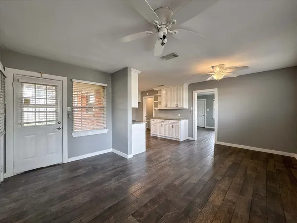 a view of empty room with wooden floor and window