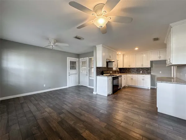 a view of kitchen with refrigerator stove microwave and cabinets