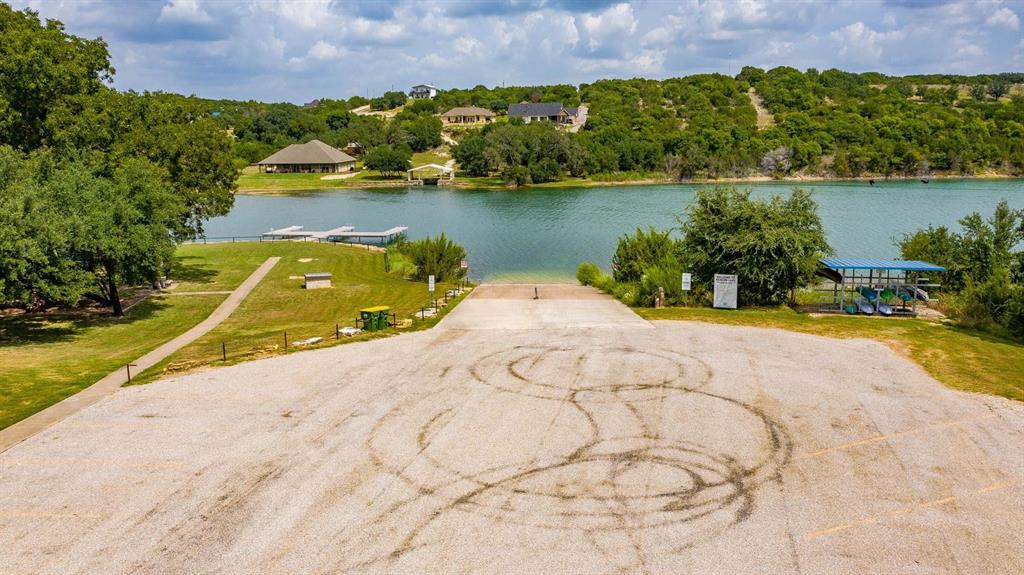 915 Anchor Way Bluff Dale, TX 76433 - Photo 26 of 37 a view of a lake with a yard and a wooden bridge