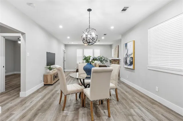 a kitchen with stainless steel appliances kitchen island granite countertop a table chairs and white cabinets