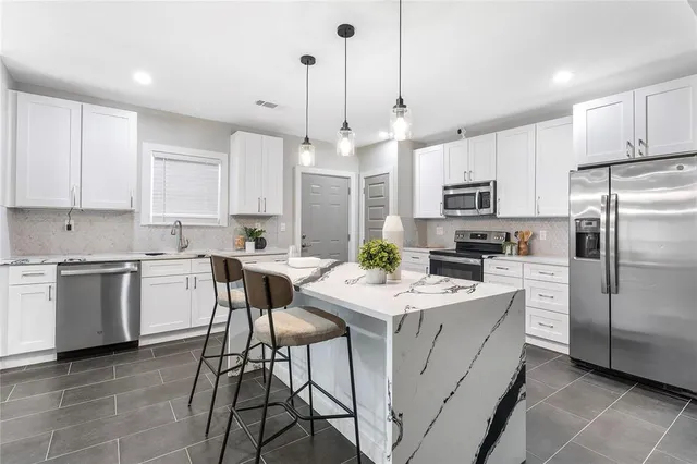 a kitchen with white cabinets and stainless steel appliances