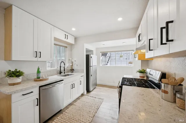 a view of a sink a mirror and a vase of flowers