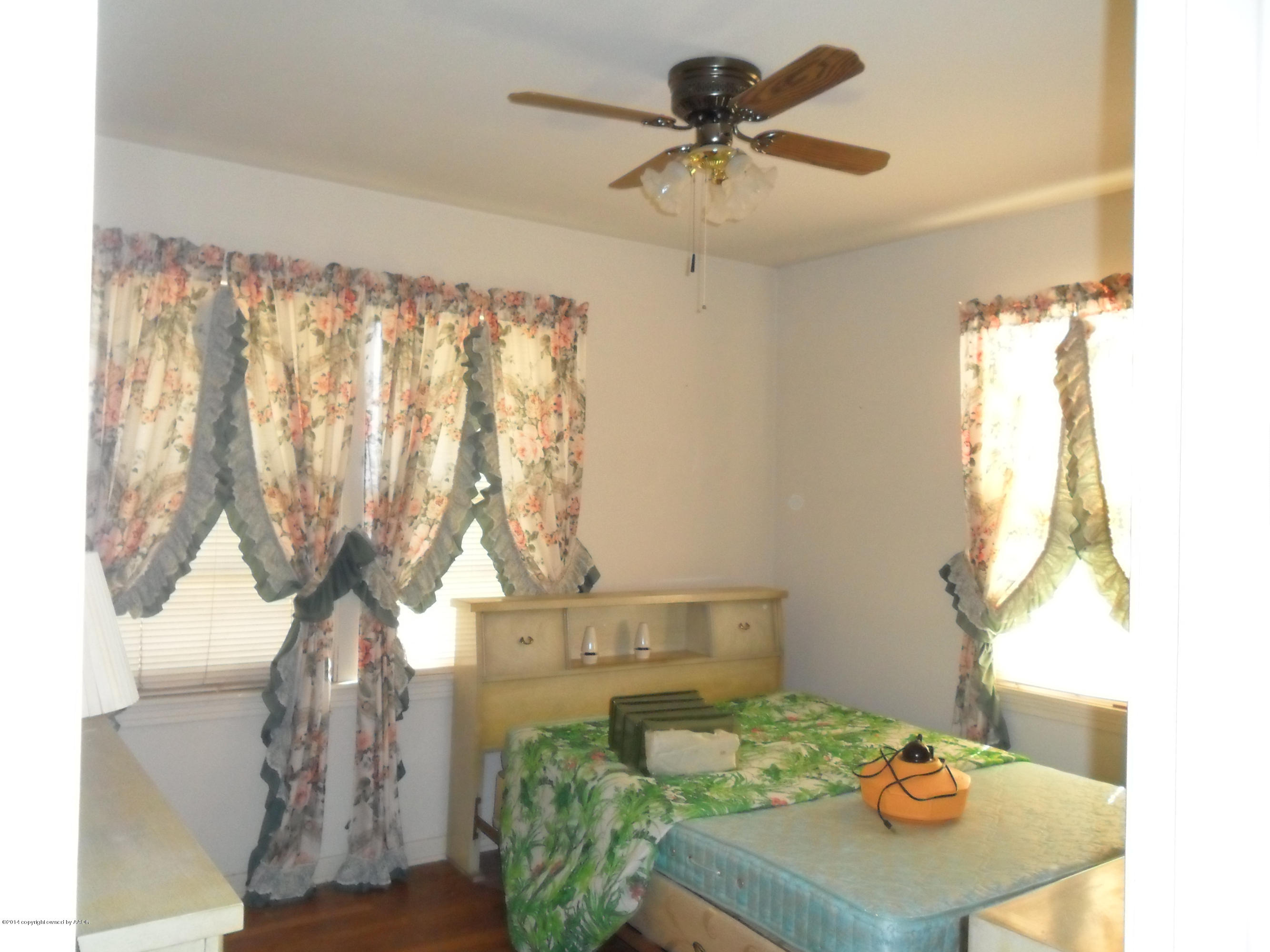 4606 Preston Street Amarillo, TX 79110 - Photo 4 of 10 a bedroom with a bed a chandelier and a table