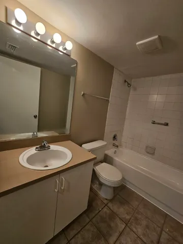 a bathroom with a granite countertop sink toilet a large mirror and a shower