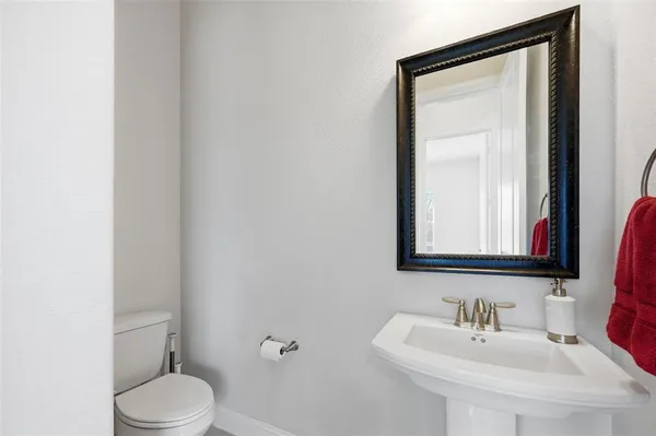 a bathroom with a toilet a sink and mirror