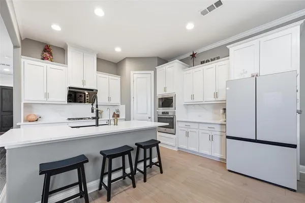 a kitchen with white cabinets and white appliances