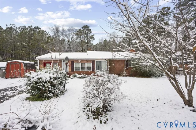 a front view of a house with a yard covered with snow