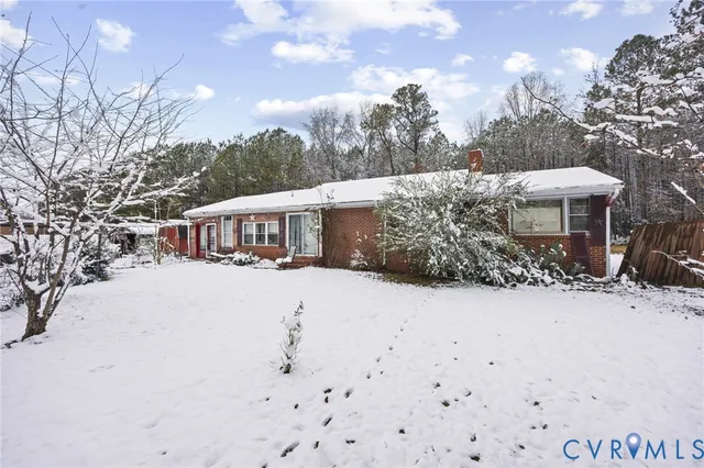 a front view of a house with a yard covered with snow in front of house