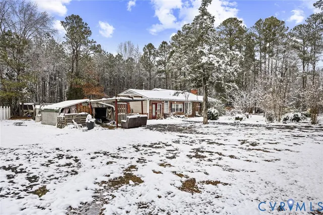 a front view of a house with a yard covered in snow