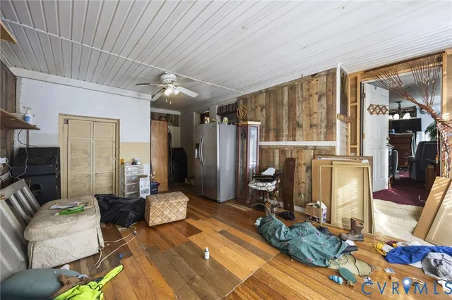 a living room with furniture a wooden floor and next to a window